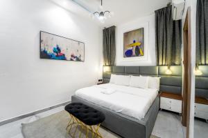 a bedroom with a bed and two chairs in it at One90 Apartment in Lagos