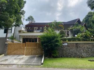a house with a fence and a stone wall at Villa New IMS in Bandung