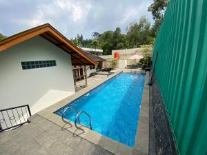 an image of a swimming pool next to a building at Villa New IMS in Bandung