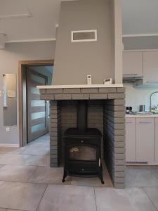 a brick fireplace in a kitchen with a stove at domek Lawendowy na wiejskiej in Lubiatowo