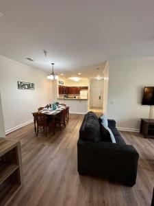 a living room with a black couch and a table at Florida Vacation Condo - No Resort Fees in Kissimmee