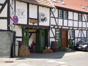 a building with green doors and a person sitting outside at Relaxen im alten Winzerhaus Fewo OG in Rech