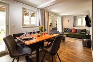 a living room with a wooden table and chairs at Haus Vogl Anger - Ferienwohnungen mit privater Sauna und beheizten Salzwasser Pool in Panoramalage und Nähe zu Salzburg und Berchtesgaden in Anger