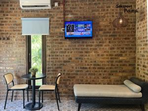 a living room with a couch and a tv on a brick wall at Sekepeng Penarek II in Kampung Penarik