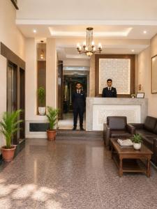 two men in suits standing behind a counter in a lobby at Hotel Star Grand - Premium Budget Hotel Near Taj mahal, in Agra