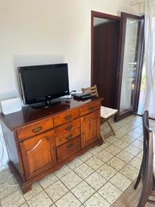 a television sitting on top of a wooden dresser at Apartmani Krk in Krk