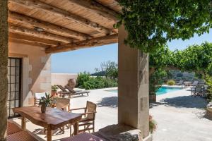 an outdoor patio with a table and chairs and a pool at Kamares Private Pool stone Villa in Makhairoí