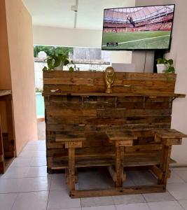 a wooden bench with a tv on a wall at Hostel Treebu in Valladolid