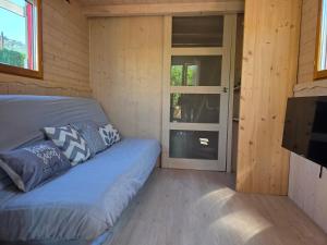 a small room with a couch and a door at Ailéa Tiny House avec jacuzzi privatif in Beaumes-de-Venise