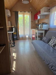 a bedroom with a bed in a small room at Ailéa Tiny House avec jacuzzi privatif in Beaumes-de-Venise