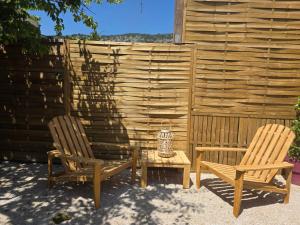 two chairs and a table in front of a fence at Ailéa Tiny House avec jacuzzi privatif in Beaumes-de-Venise