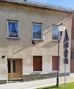 ein Gebäude mit drei Garagentoren und einer Straßenlaterne in der Unterkunft Miniapartement in Netzschkau