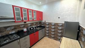 a kitchen with red cabinets and a counter top at Appartement Agadir T2 pour couples maries et familles in Agadir