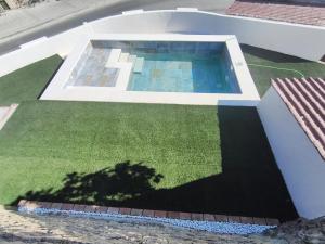 an image of a backyard with a swimming pool and grass at Casas las Lanzas 1 in Setenil