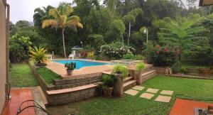 a swimming pool in a yard with plants and trees at Garden View in Guarata