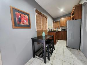 a kitchen with a black table and a refrigerator at Garden View in Guarata +15 photos