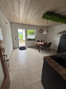 una cucina e una sala da pranzo con tavolo e sedie di MaRe FeWo a Hettingen