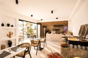 a restaurant with tables and chairs and a counter with a kitchen at Kouros Home & Suites--Faliraki--Adults Only in Faliraki