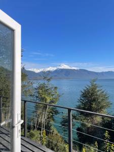a balcony with a view of the water and mountains at Cabaña Puelo-Cochamó Tiny house in Sotomó