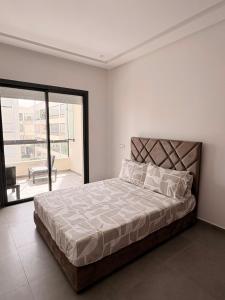a bedroom with a large bed and a large window at Magic House T5 -El Mansouria in Mansouria