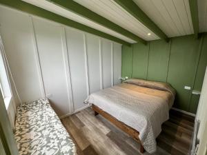 a small bedroom with a bed and a couch at Cabaña Puelo-Cochamó Tiny house in Sotomó