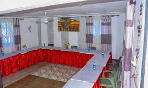 a conference room with a red table and chairs at La Bella resort in Mombasa