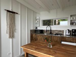 a kitchen with a wooden table and a counter top at Cabaña Puelo-Cochamó Tiny house in Sotomó
