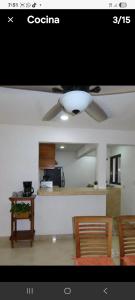 a living room with a ceiling fan and a kitchen at Casa puerto in Progreso