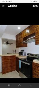 a kitchen with wooden cabinets and a black stove top oven at Casa puerto in Progreso