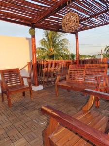 a patio with wooden benches and a wooden pergola at Casa puerto in Progreso