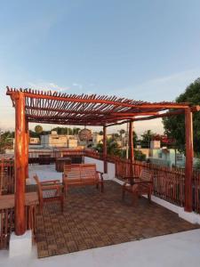 a wooden pergola with benches on a patio at Casa puerto in Progreso +3 photos
