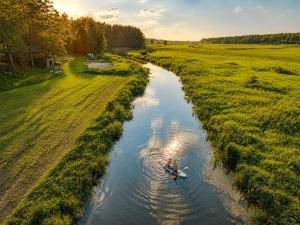 a person in a boat in a river at Domki nad rzeką Narew in Ploski +30 photos