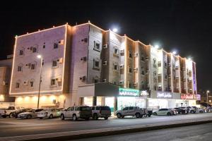 a large building with cars parked in front of it at شقق راف التميز in Umm Salam