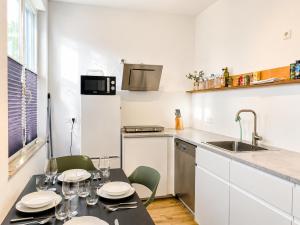a kitchen with a table with chairs and a sink at SCHEE Apartments - stilvolle & zentrale Wohnungen mit Privatparkplatz in Nördlingen +51 photos