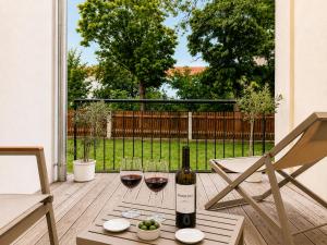 a bottle of wine and two glasses on a patio at SCHEE Apartments - stilvolle & zentrale Wohnungen mit Privatparkplatz in Nördlingen