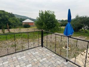 a blue umbrella on a fence with a dog at xanagah aframe in Qala +1 photo