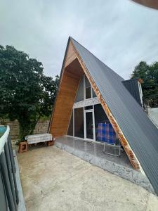 a house with a gambrel roof with a bench at xanagah aframe in Qala