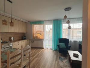 a kitchen and living room with a table and a dining room at Apartament Color4you Blue in Wschowa
