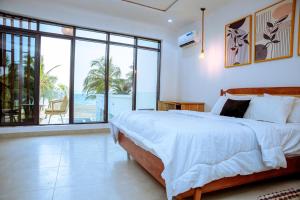 a bedroom with a bed and a view of the ocean at Atlantic Shores Resort in Igbolobi +59 photos