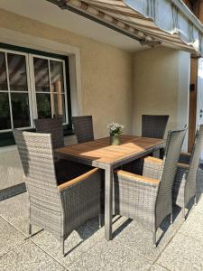 a wooden table with wicker chairs on a patio at Ferienwohnung Edith-Maria in Bad Goisern