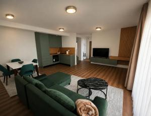 a living room with a green couch and a table at Agel Inn Apartments Mavrovo in Mavrovo