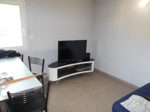a living room with a flat screen tv on a stand at studio in Saint-André-de-Sangonis