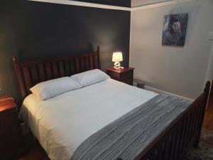 a bedroom with a large bed with white sheets at Beach Street Self-Catering in Mossel Bay