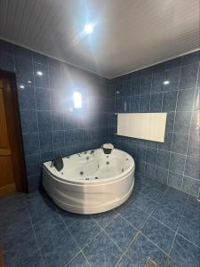 a bath tub in a blue tiled bathroom at house chito in Tsqaltubo +9 photos
