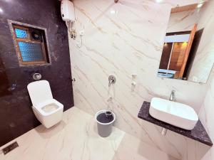 a bathroom with a sink and a toilet and a mirror at Hotel Kanaka Residency in Mangrul +54 photos