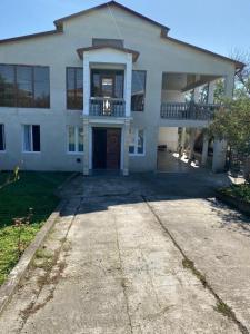 a large white house with a driveway in front of it at house chito in Tsqaltubo