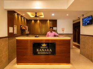 a man standing behind a bar in a hotel karma residency at Hotel Kanaka Residency in Mangrul