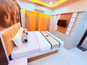 a small room with a bed and a tv at Hotel Kanaka Residency in Mangrul