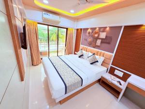 a bedroom with a bed and a desk and a window at Hotel Kanaka Residency in Mangrul