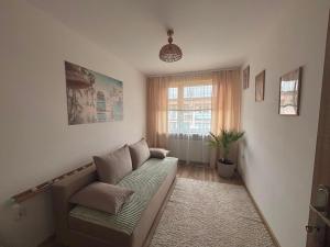 a living room with a couch and a window at Apartament Color4you Blue in Wschowa